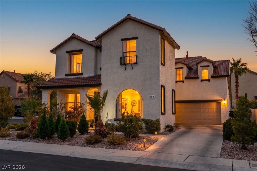 3018 Via Sarafina Drive, Henderson, NV 89052 Spanish-style architecture highlights this multi-level stucco home featuring a tiled roof and arched window.