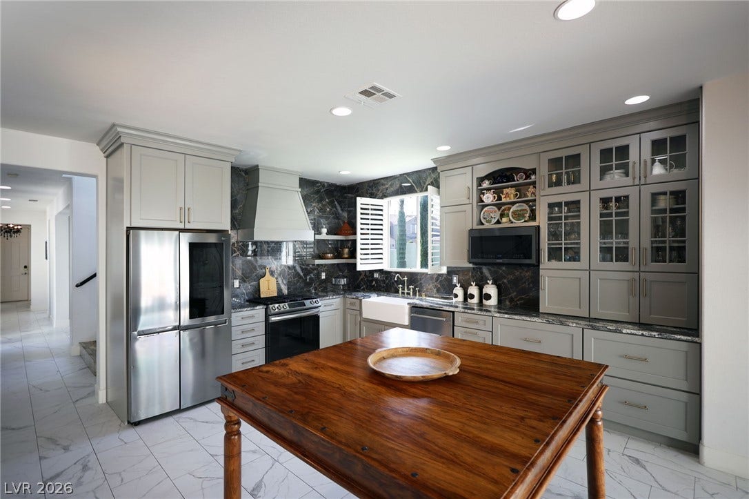 3018 Via Sarafina Drive, Henderson, NV 89052 Rich stone backsplashes and classic cabinetry frame this beautifully appointed workspace.