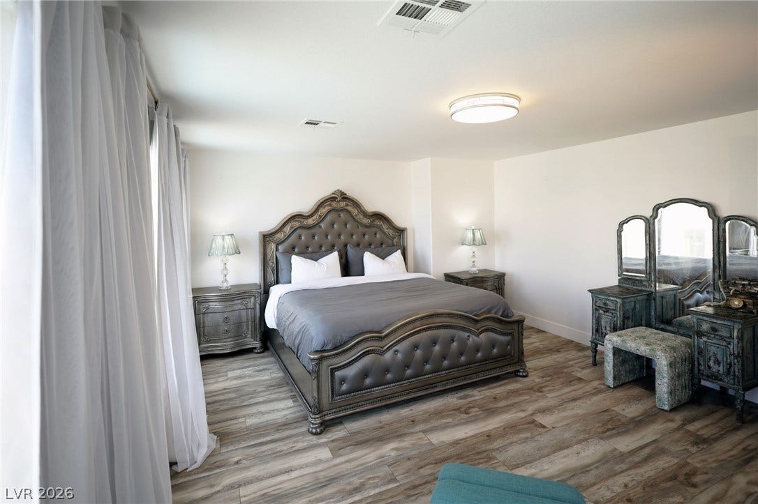 3018 Via Sarafina Drive, Henderson, NV 89052 Gleaming wood-look floors and clean white walls establish a serene, contemporary bedroom design.