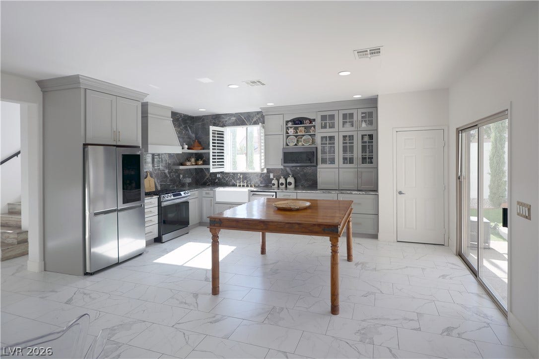 3018 Via Sarafina Drive, Henderson, NV 89052 Gleaming stone tile floors anchor this modern kitchen featuring customized cabinetry and premium appliances.
