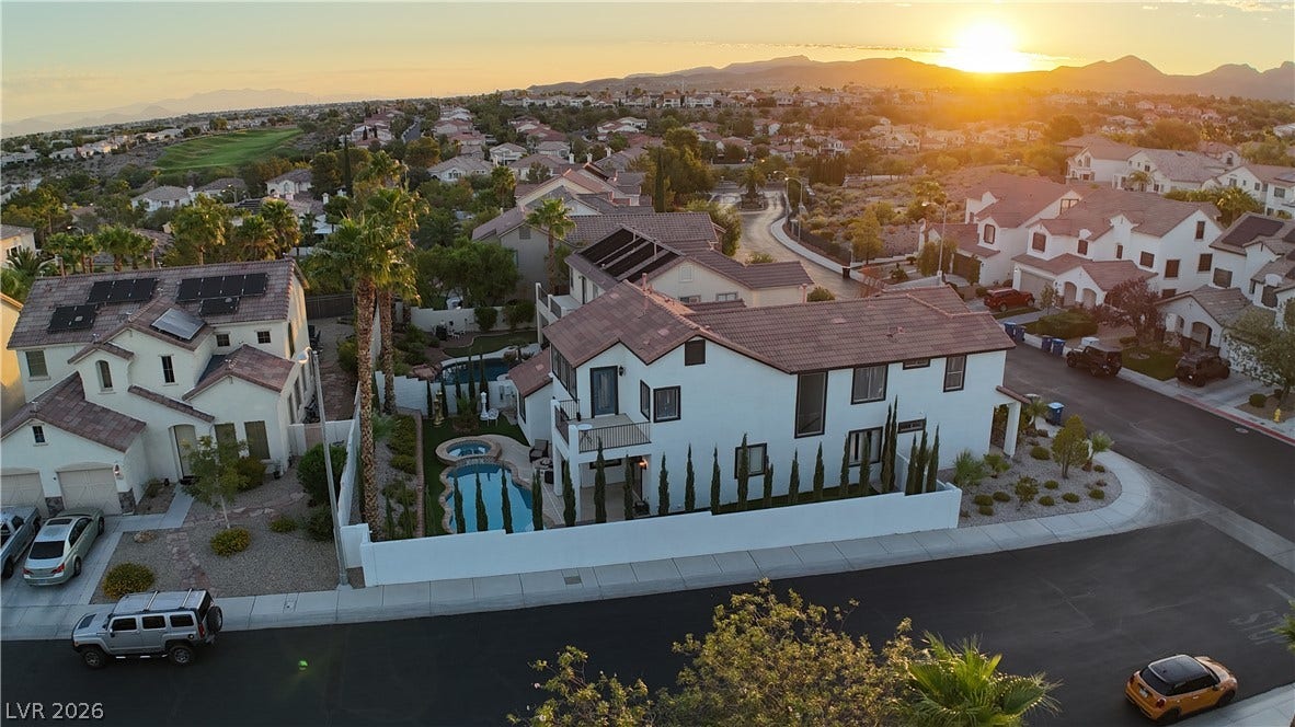 3018 Via Sarafina Drive, Henderson, NV 89052 Sunlight washes over a suburban neighborhood featuring tile roofs and backyard swimming pools.