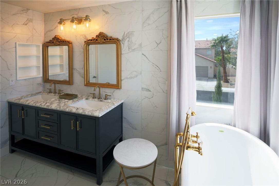3018 Via Sarafina Drive, Henderson, NV 89052 Elegant marble tile surrounds a double vanity and freestanding soaking tub in this bathroom.