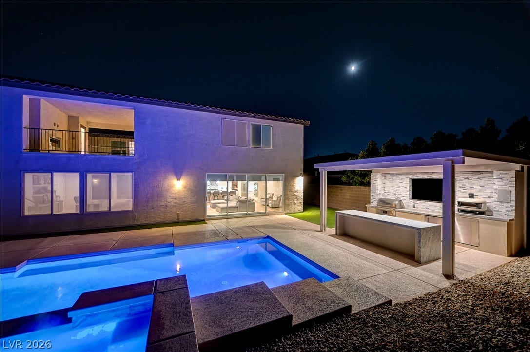 4709 Amazing View Street, Las Vegas, NV 89129 An inviting backyard oasis features a gleaming pool alongside a fully equipped covered outdoor kitchen.