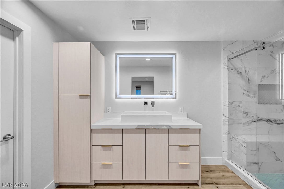 4709 Amazing View Street, Las Vegas, NV 89129 Sleek vanity cabinetry and marble-look tile enrich this contemporary washroom.