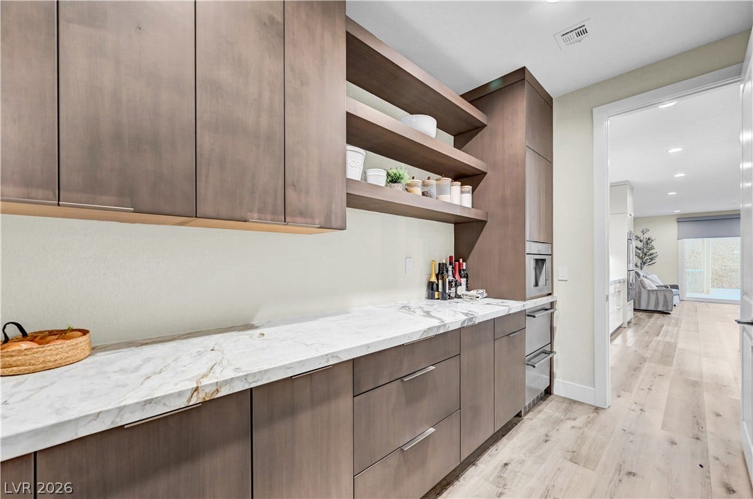4709 Amazing View Street, Las Vegas, NV 89129 A spacious butler pantry features warm wood cabinetry and elegant stone countertops.