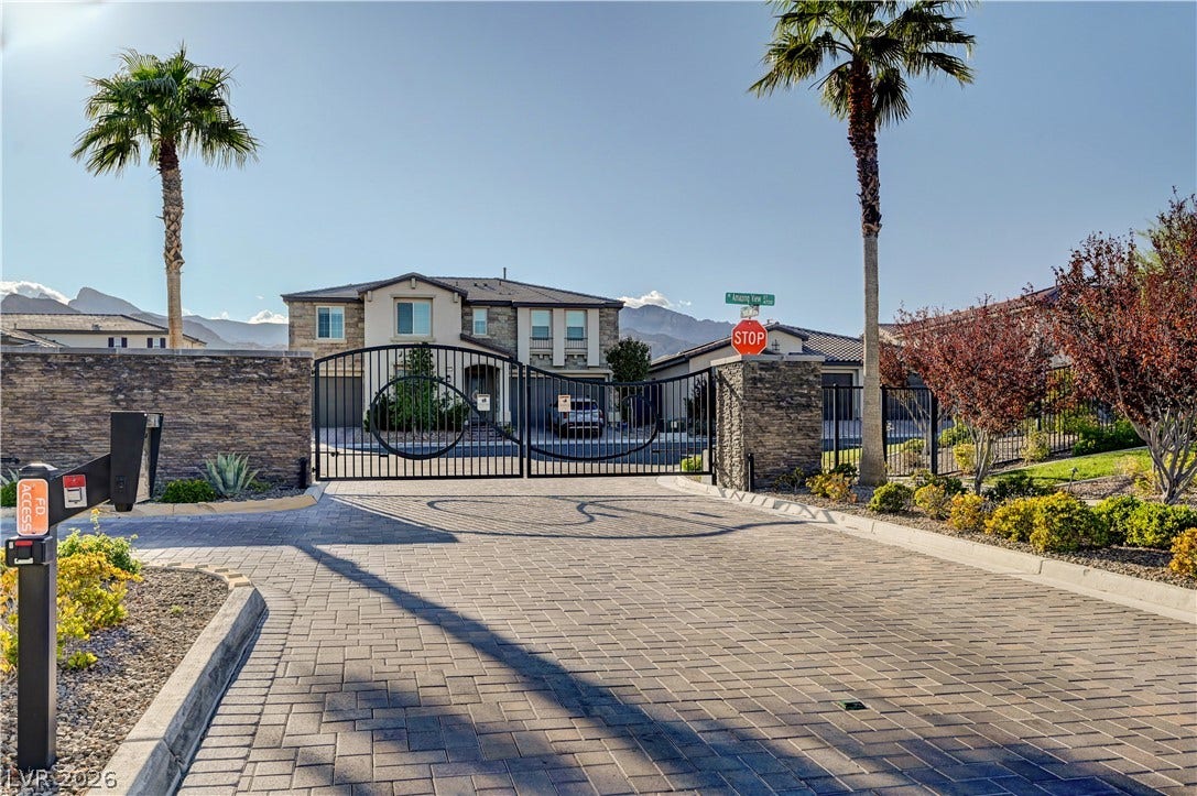 4709 Amazing View Street, Las Vegas, NV 89129 A secure gated entrance features detailed paver stone driveway surfaces under clear blue skies.