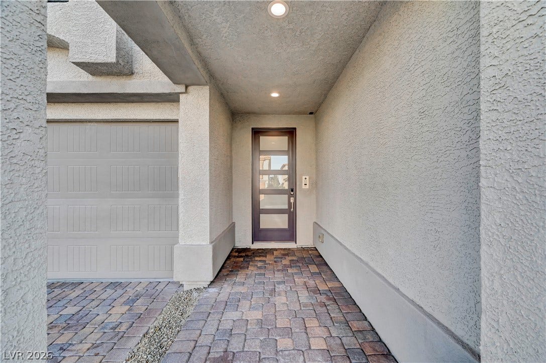 4709 Amazing View Street, Las Vegas, NV 89129 A recessed entryway features textured stucco walls and a patterned paver path leading to the front door.