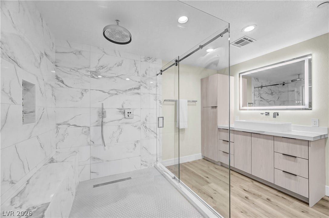 4709 Amazing View Street, Las Vegas, NV 89129 Elegant stone tiling accents a large glass-enclosed shower next to a modern vanity.