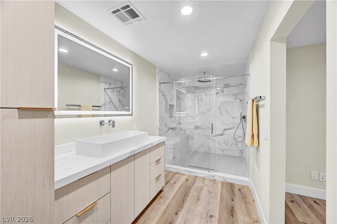 4709 Amazing View Street, Las Vegas, NV 89129 Modern stone counters and custom cabinetry elevate this sleek bathroom design.