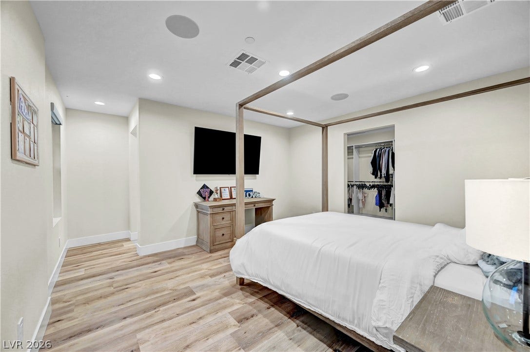 4709 Amazing View Street, Las Vegas, NV 89129 Recessed lighting illuminates this bedroom finished with wood flooring and a walk-in closet.