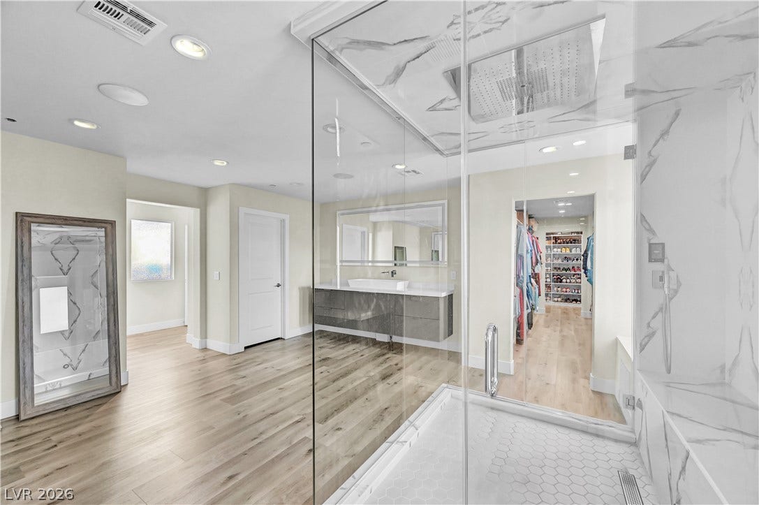 4709 Amazing View Street, Las Vegas, NV 89129 A glass-enclosed shower highlights this modern bath featuring dual vanities and light wood floors.