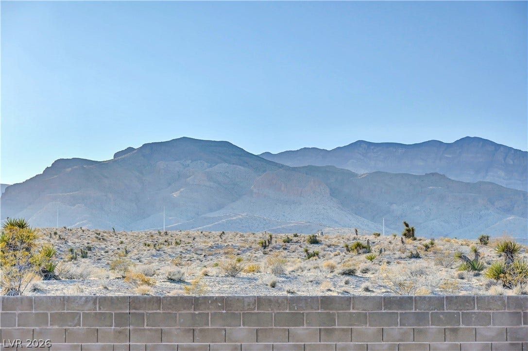 4709 Amazing View Street, Las Vegas, NV 89129 Dramatic mountain ridges rise above the desert terrain beyond a concrete block boundary wall.