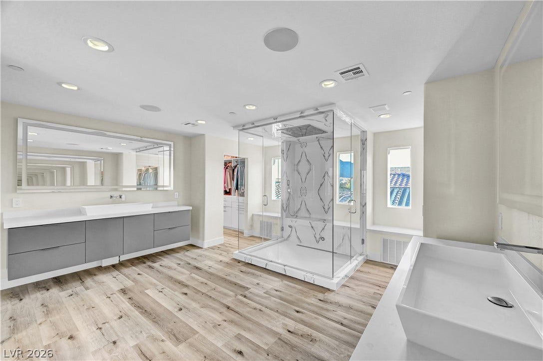 4709 Amazing View Street, Las Vegas, NV 89129 A glass-enclosed walk-in shower anchors this modern main bath featuring warm wood-look floors.