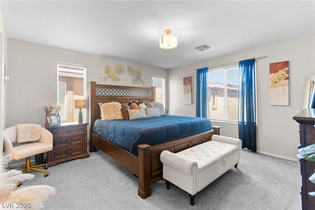 7224 Halo Falls Street, North Las Vegas, NV 89084 Relax in this well-lit primary bedroom featuring soft carpeted flooring and large windows.