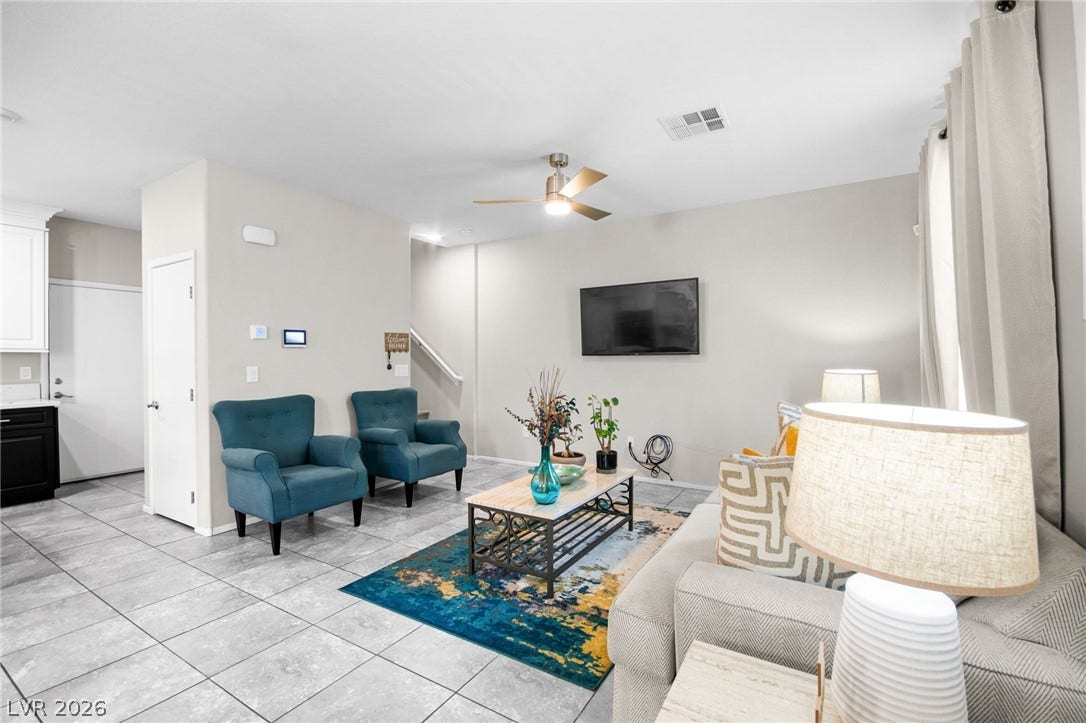 7224 Halo Falls Street, North Las Vegas, NV 89084 A comfortable living area featuring tile flooring, a refreshing ceiling fan, and access to a contemporary kitchen.