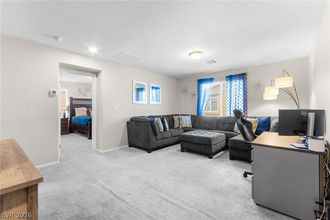 7224 Halo Falls Street, North Las Vegas, NV 89084 A well-lit casual living space features comfortable seating and a dedicated workstation.