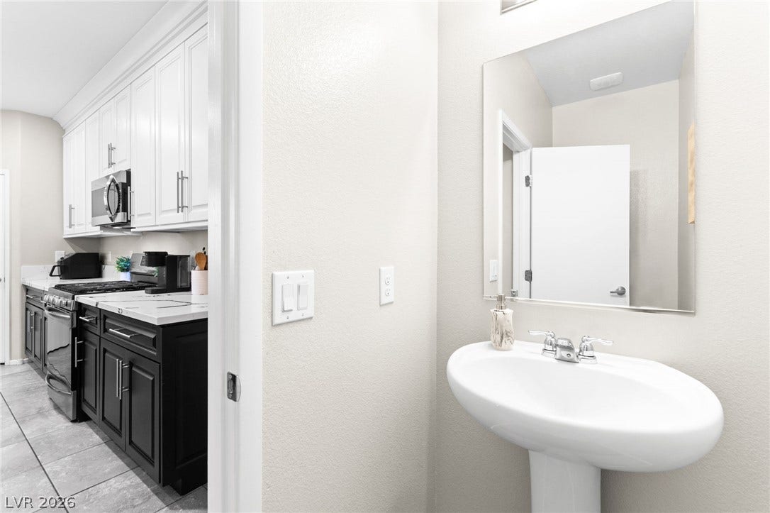 7224 Halo Falls Street, North Las Vegas, NV 89084 Functional kitchen with stylish two-tone cabinetry and an adjoining, well-appointed half bath.