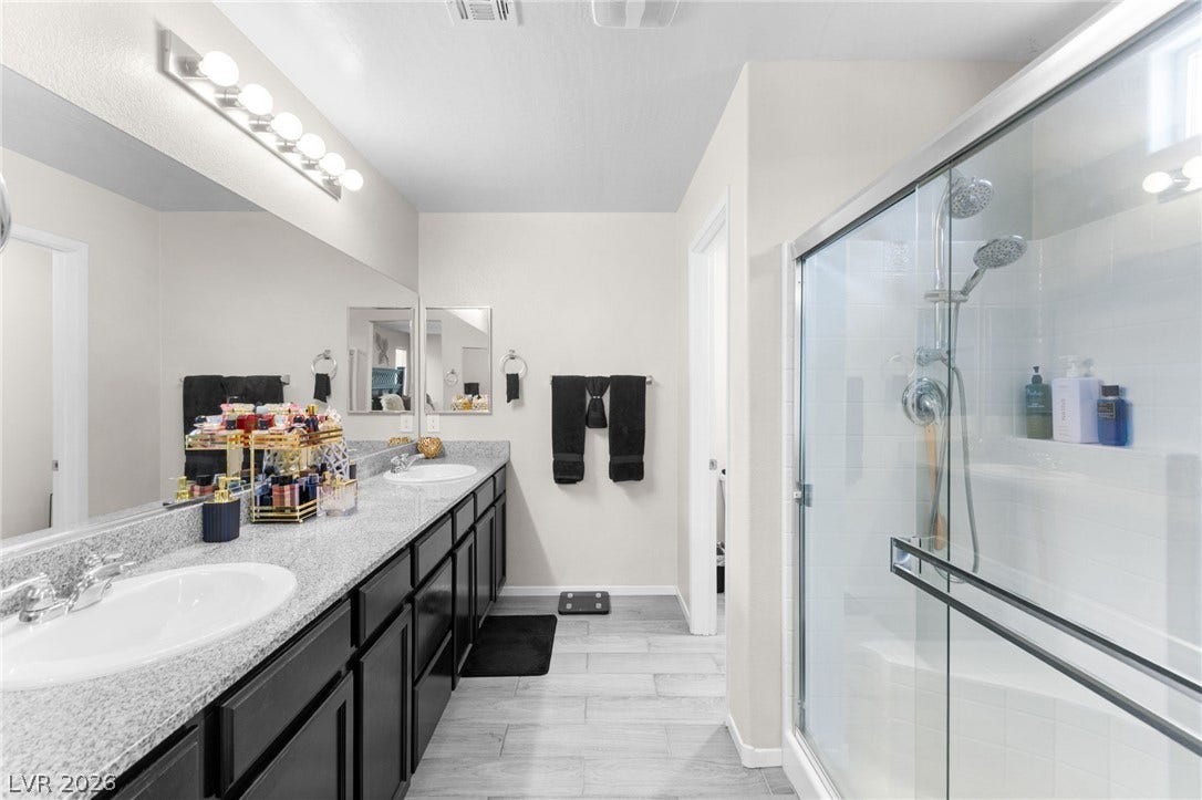 7224 Halo Falls Street, North Las Vegas, NV 89084 A generous double vanity offers ample counter space, complemented by a sleek glass-enclosed shower.