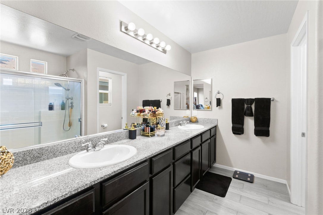 7224 Halo Falls Street, North Las Vegas, NV 89084 Double vanity with sleek granite counters defines this well-appointed primary bathroom.