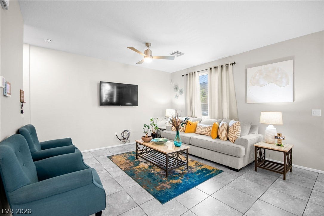 7224 Halo Falls Street, North Las Vegas, NV 89084 Relax in this inviting living area featuring a ceiling fan and large windows for natural light.