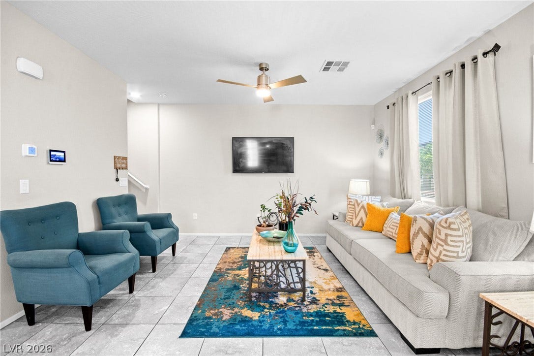 7224 Halo Falls Street, North Las Vegas, NV 89084 Step into this well-lit living area featuring contemporary tile flooring and a ceiling fan for comfort.