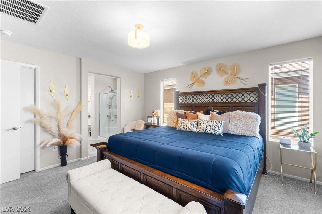 7224 Halo Falls Street, North Las Vegas, NV 89084 Plush carpeting defines this primary bedroom, offering a serene escape with direct access to a private bathroom.