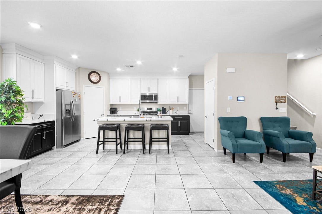 7224 Halo Falls Street, North Las Vegas, NV 89084 A pristine open-concept kitchen with sleek white cabinetry, an island, and modern stainless steel appliances.