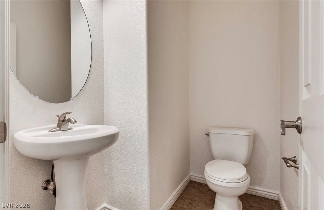4709 Estate Ranch Street, North Las Vegas, NV 89031 A compact powder room with a sleek pedestal sink and a clean, functional toilet.