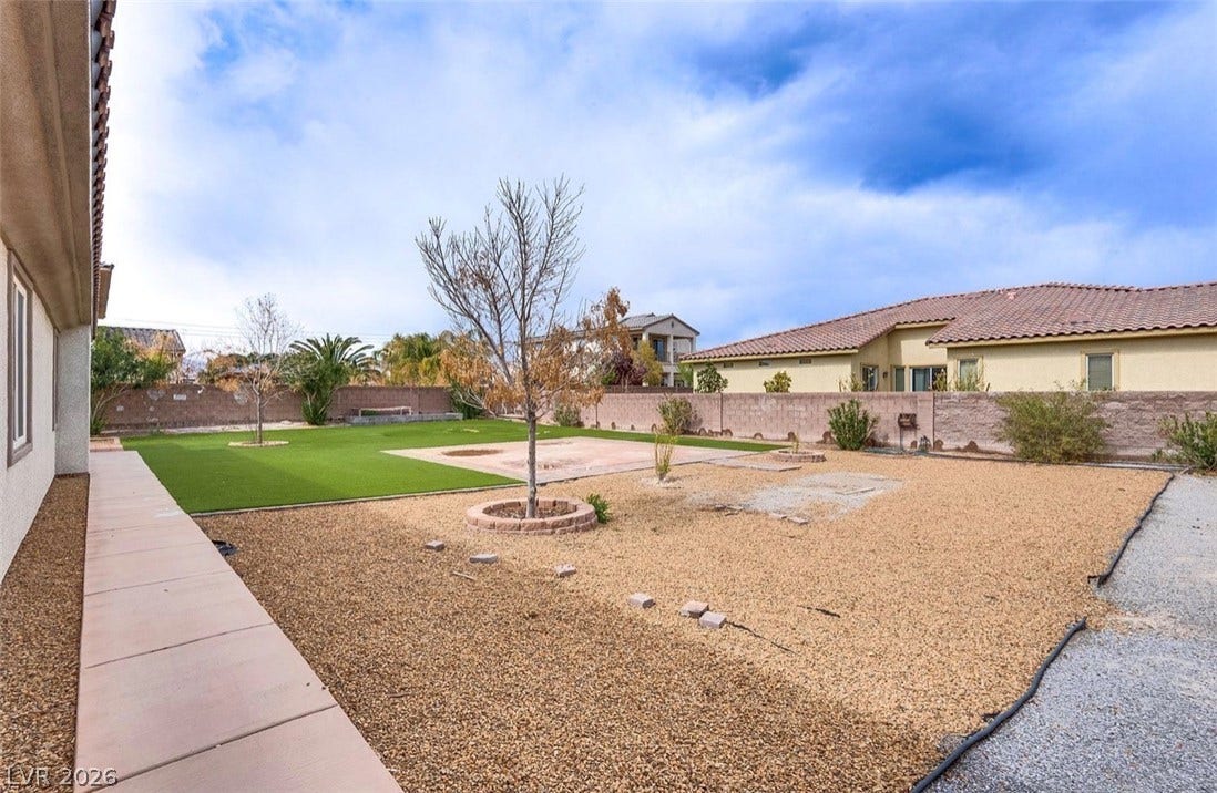 4709 Estate Ranch Street, North Las Vegas, NV 89031 A low-maintenance backyard boasts both gravel and artificial turf, offering versatile outdoor living.