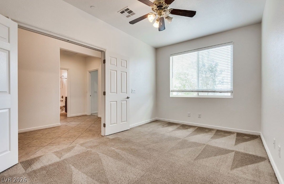 4709 Estate Ranch Street, North Las Vegas, NV 89031 A versatile room features soft carpeting, a refreshing ceiling fan, and access to an adjoining tiled space.