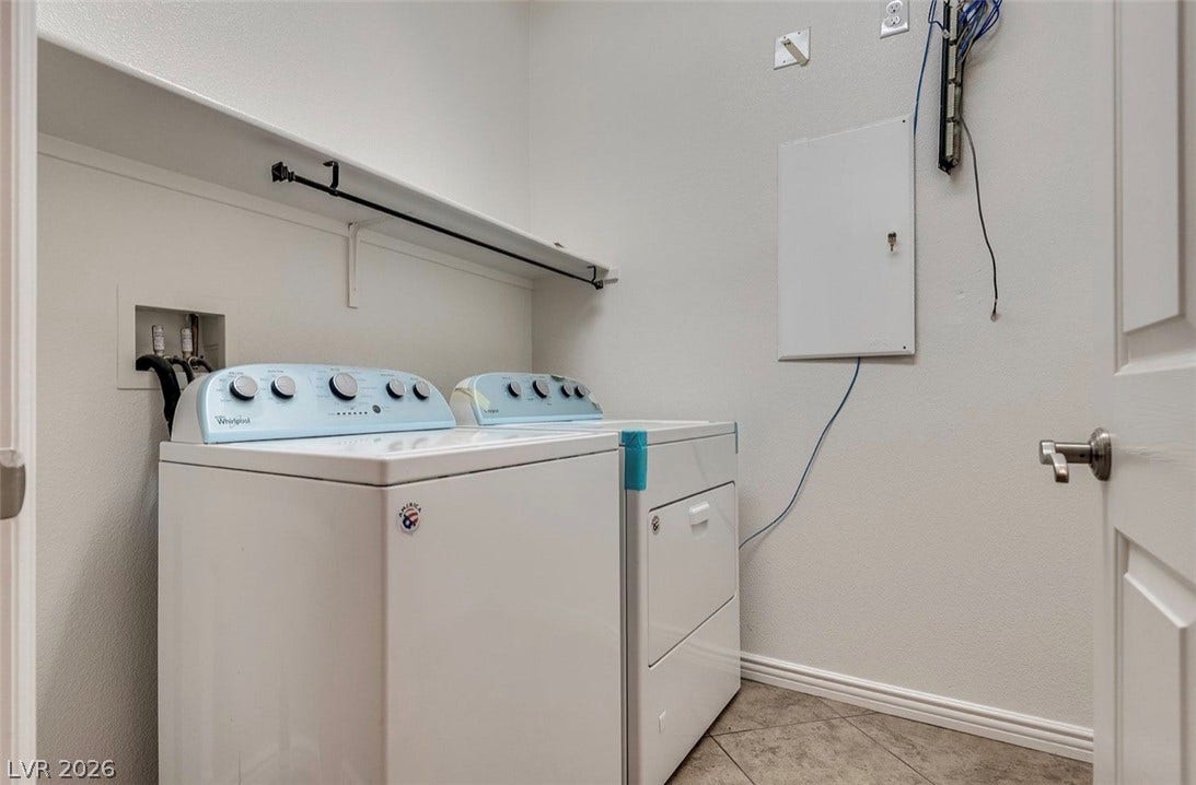 4709 Estate Ranch Street, North Las Vegas, NV 89031 Functional laundry space featuring modern appliances, durable tile flooring, and essential utility hookups for daily ease.