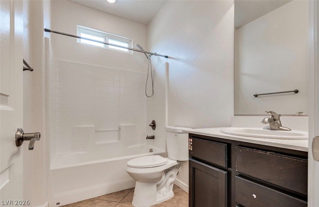 4709 Estate Ranch Street, North Las Vegas, NV 89031 Tiled flooring and a practical shower-over-bath combination define this functional bathroom.