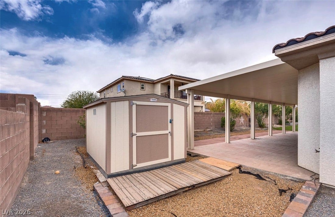 4709 Estate Ranch Street, North Las Vegas, NV 89031 A private backyard oasis features a useful storage shed and a shaded patio for outdoor leisure.