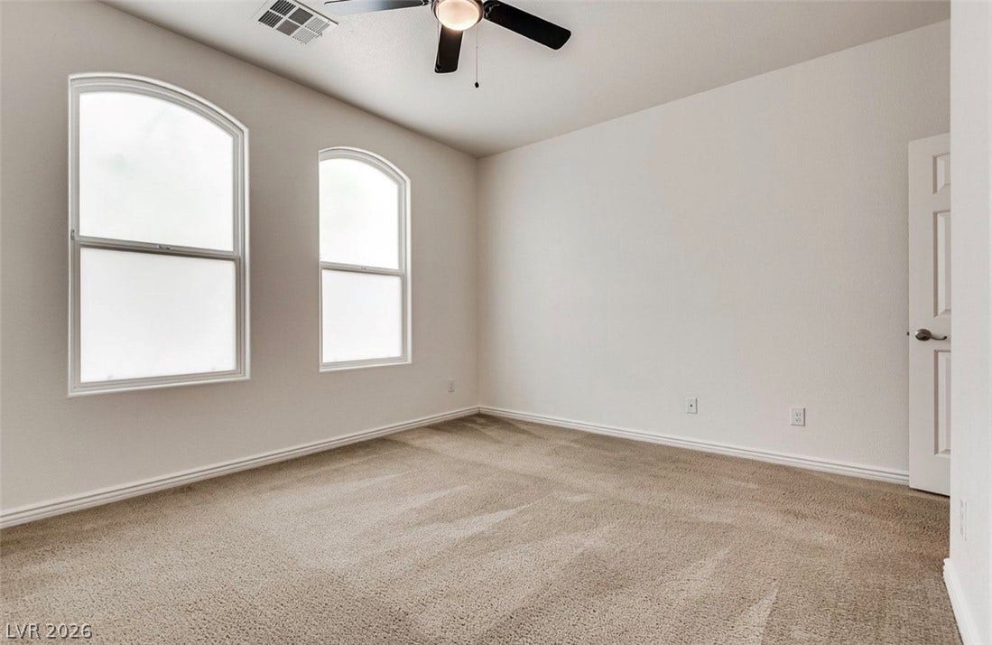 4709 Estate Ranch Street, North Las Vegas, NV 89031 Arched windows illuminate this quiet bedroom, offering a serene personal retreat.