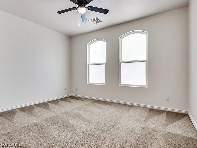 4709 Estate Ranch Street, North Las Vegas, NV 89031 Sun-filled bedroom featuring elegant arched windows and plush patterned carpeting.