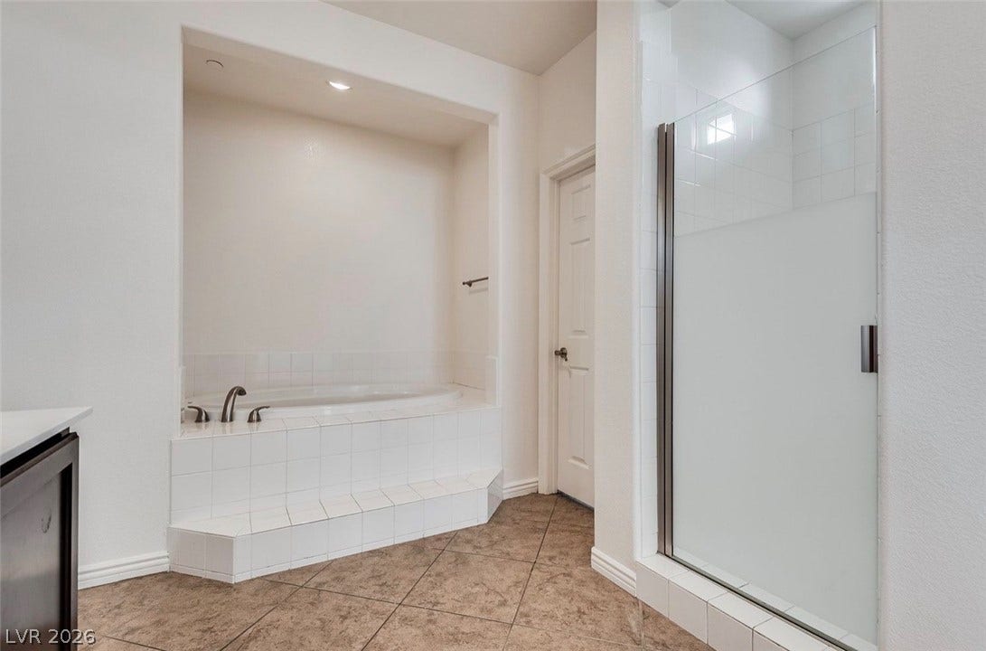 4709 Estate Ranch Street, North Las Vegas, NV 89031 Indulge in a tranquil bathing experience with this deep soaking tub and tiled shower.