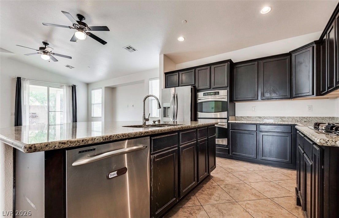 4709 Estate Ranch Street, North Las Vegas, NV 89031 Culinary delights await in this chef's kitchen, featuring abundant cabinetry and sleek stainless steel appliances.