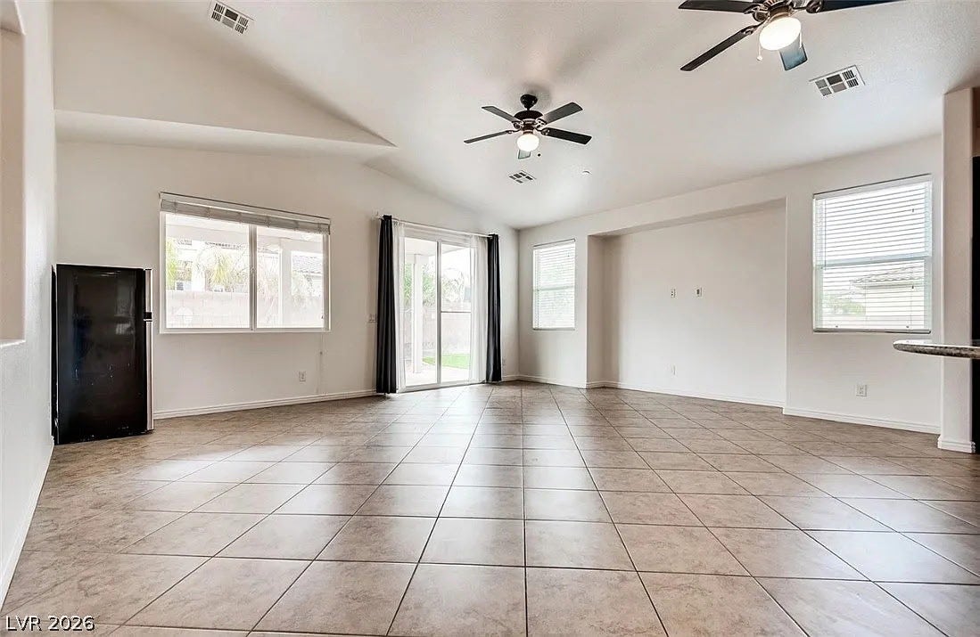 4709 Estate Ranch Street, North Las Vegas, NV 89031 A spacious living area featuring tiled floors, vaulted ceilings, and generous natural light.