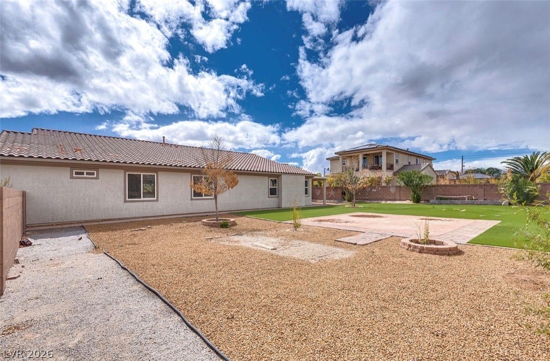 4709 Estate Ranch Street, North Las Vegas, NV 89031 A spacious backyard with a mix of gravel and artificial turf provides ample outdoor leisure space.