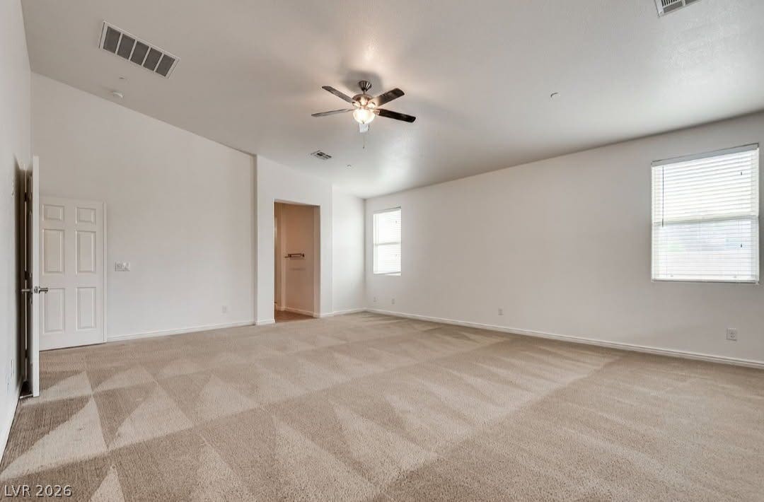 4709 Estate Ranch Street, North Las Vegas, NV 89031 A spacious, naturally illuminated room featuring plush carpeting and a cooling ceiling fan.