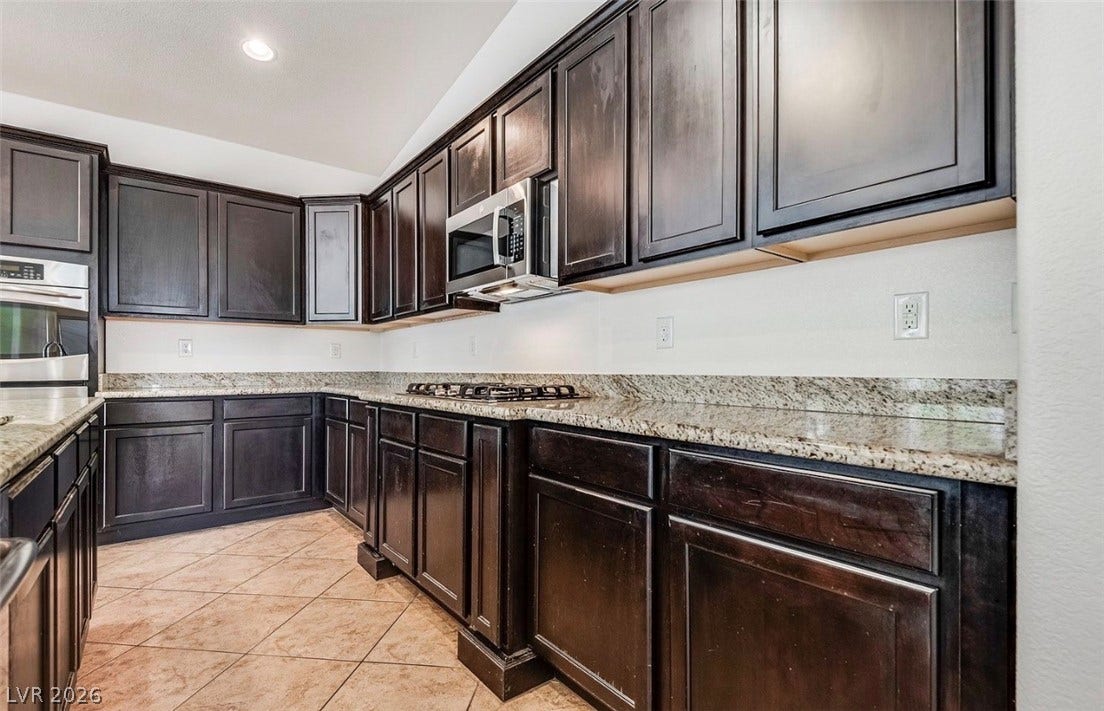 4709 Estate Ranch Street, North Las Vegas, NV 89031 Modern kitchen with rich wood cabinetry and ample countertop space.