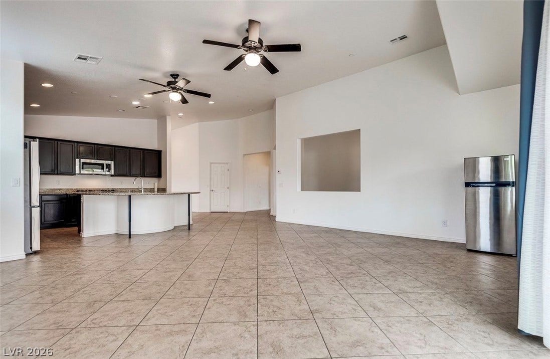 4709 Estate Ranch Street, North Las Vegas, NV 89031 An open-concept living area with vaulted ceilings and recessed lighting flows into a modern kitchen.