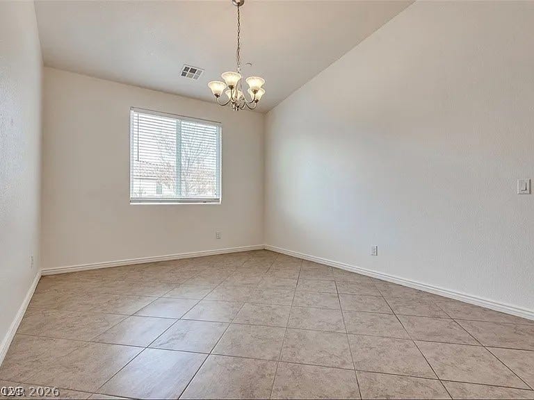 4709 Estate Ranch Street, North Las Vegas, NV 89031 A well-lit, neutral-toned room features a vaulted ceiling and tile flooring.