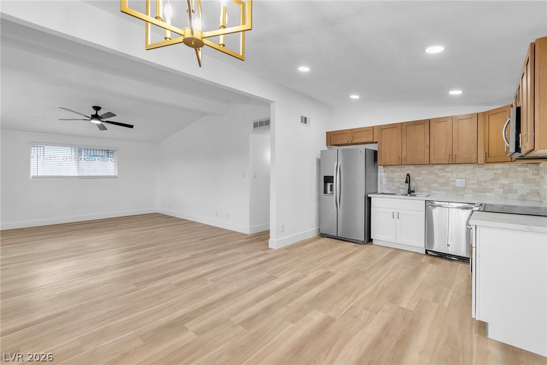 1604 Basswood Avenue, North Las Vegas, NV 89030 Gleaming wood-look floors unite the open kitchen and adjacent living area seamlessly.