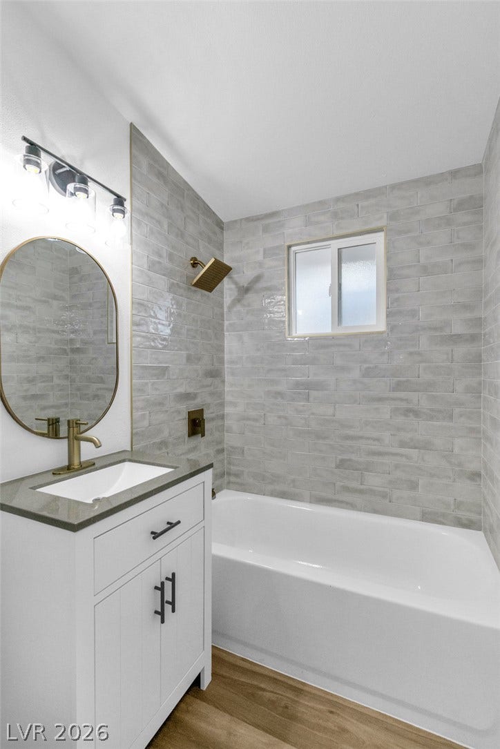 1604 Basswood Avenue, North Las Vegas, NV 89030 Elegant tile surrounds the alcove tub in this modern bath with warm wood flooring.