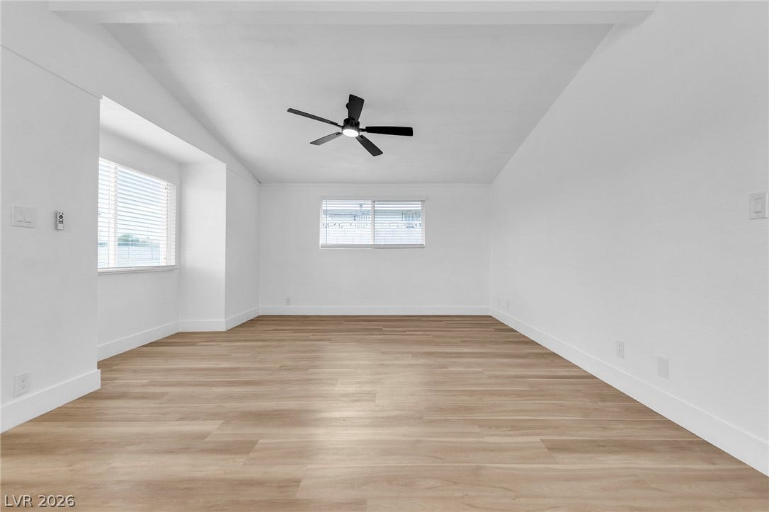1604 Basswood Avenue, North Las Vegas, NV 89030 Warm wood flooring anchors a minimalist room framed by clean walls and natural light.