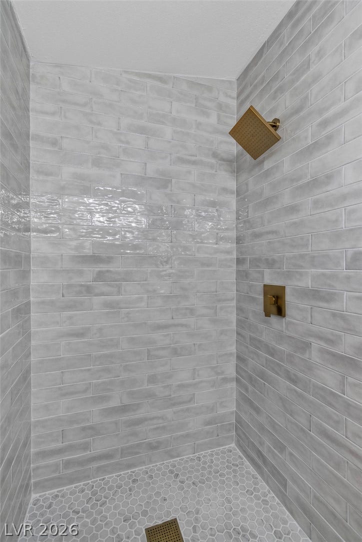 1604 Basswood Avenue, North Las Vegas, NV 89030 Glistening subway tile surrounds this contemporary walk-in shower equipped with modern gold fixtures.