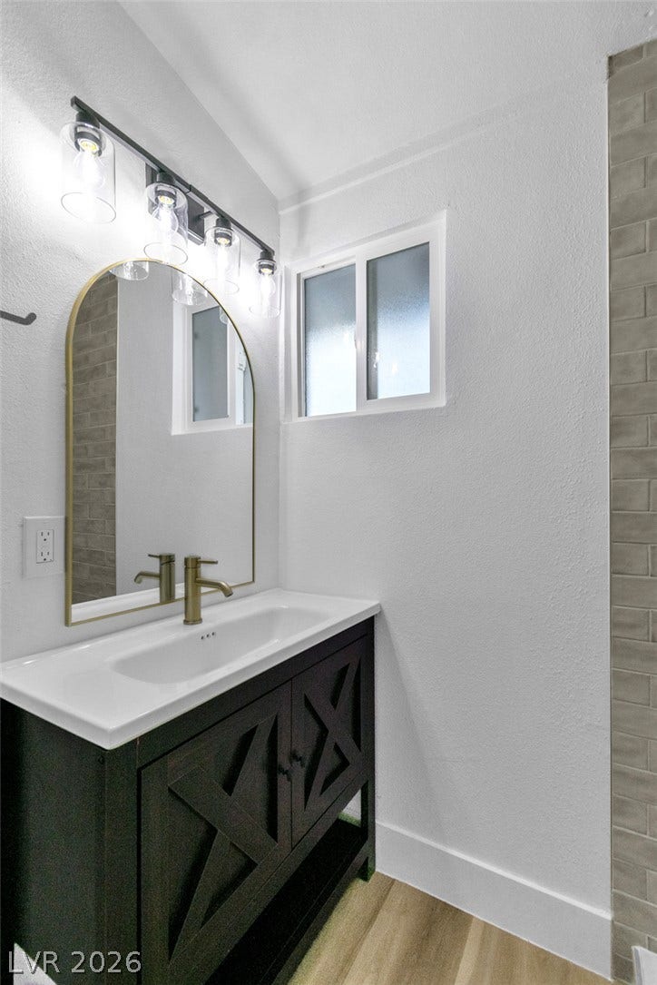 1604 Basswood Avenue, North Las Vegas, NV 89030 An elegant vanity and tiled accents highlight this modern, light-filled bathroom.