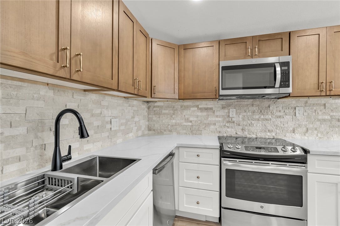 1604 Basswood Avenue, North Las Vegas, NV 89030 Crisp stone counters and textured backsplashes complement the warmth of classic wood upper cabinets.
