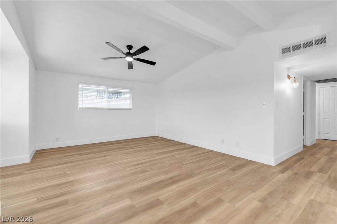 1604 Basswood Avenue, North Las Vegas, NV 89030 Beamed ceilings and warm wood-style flooring create an inviting foundation in this versatile room.
